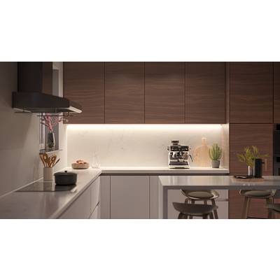 Moderne Küche mit Holzschränken, einer Kaffeemaschine auf der Arbeitsplatte und heller Beleuchtung. Ein Schubladenschrank und Dekorationsartikel sind sichtbar.