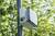 Ein Sensor an einem Mast im Freien, umgeben von grünen Blättern. Der Sensor überwacht wahrscheinlich Umweltbedingungen.