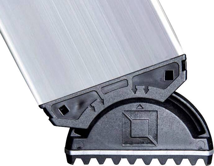 Nahaufnahme eines schwarzen, halbkreisförmigen Kunststoffteils mit gezahnter Kante, das mit einem metallischen, geriffelten Profil verbunden ist.