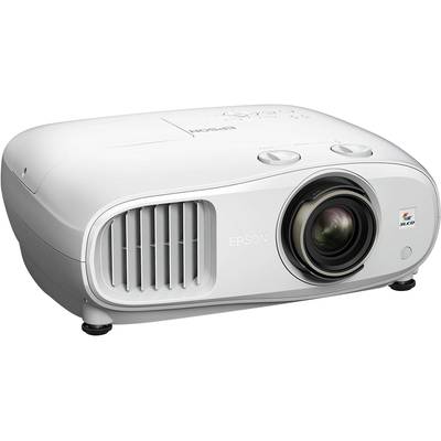 Ein weißer Projektor mit großem Objektiv und Lüftungsschlitzen an der Seite, auf einem Tisch platziert. Markenname 'Epson'.
