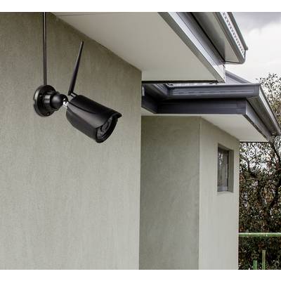 Überwachungskamera an einer modernen Hauswand installiert, zeigt Richtung Garten, um Sicherheitsüberwachung zu gewährleisten.