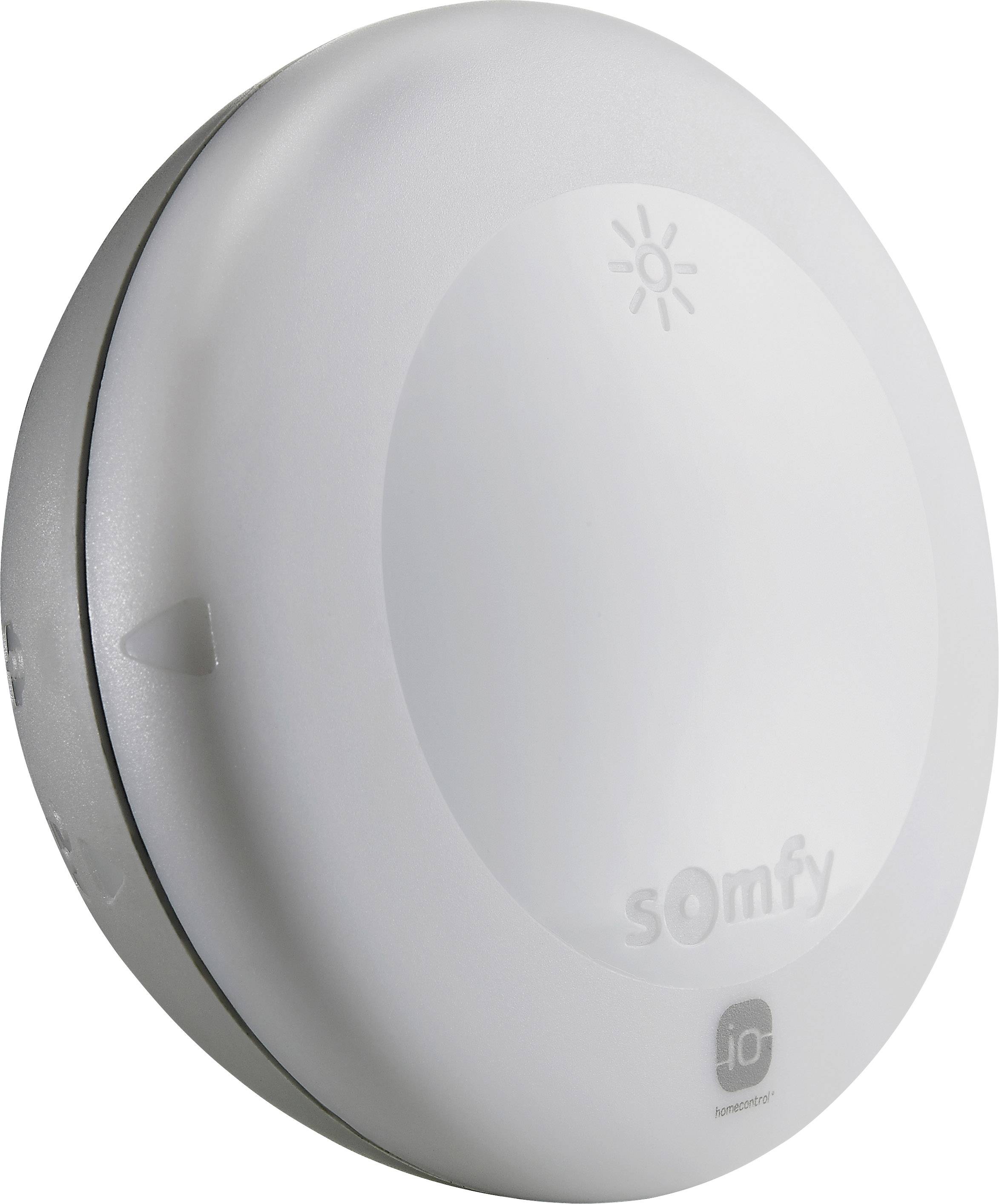 Ein weißer, runder Sensor von Somfy mit dem Logo unten und einem Lichtsymbol oben. Er ist für die Automatisierung von Heimgeräten gedacht.