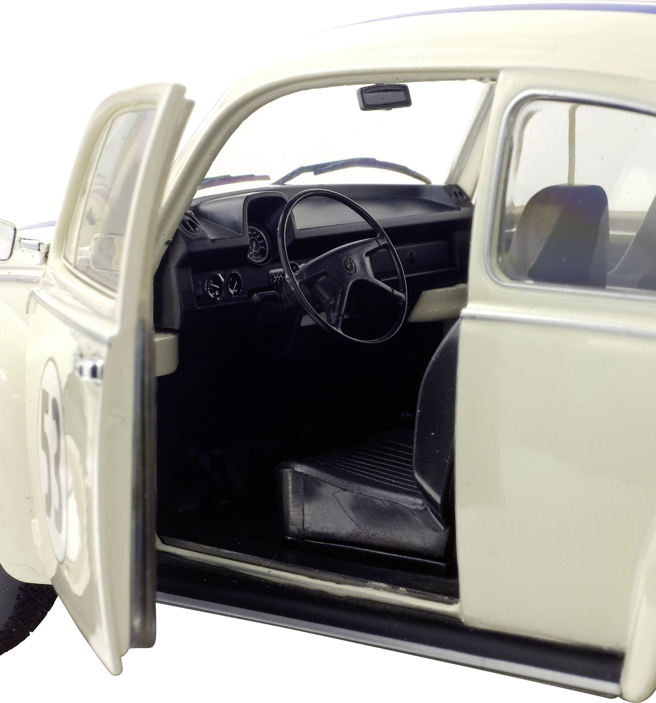 Ein geöffnetes Autotür eines weißen Oldtimers zeigt den Innenraum mit Lenkrad und Armaturenbrett.