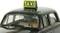 Ein schwarzes Taxi-Modellauto mit einem gelben 'TAXI'-Schild auf dem Dach, gezeigt von der Vorderseite.