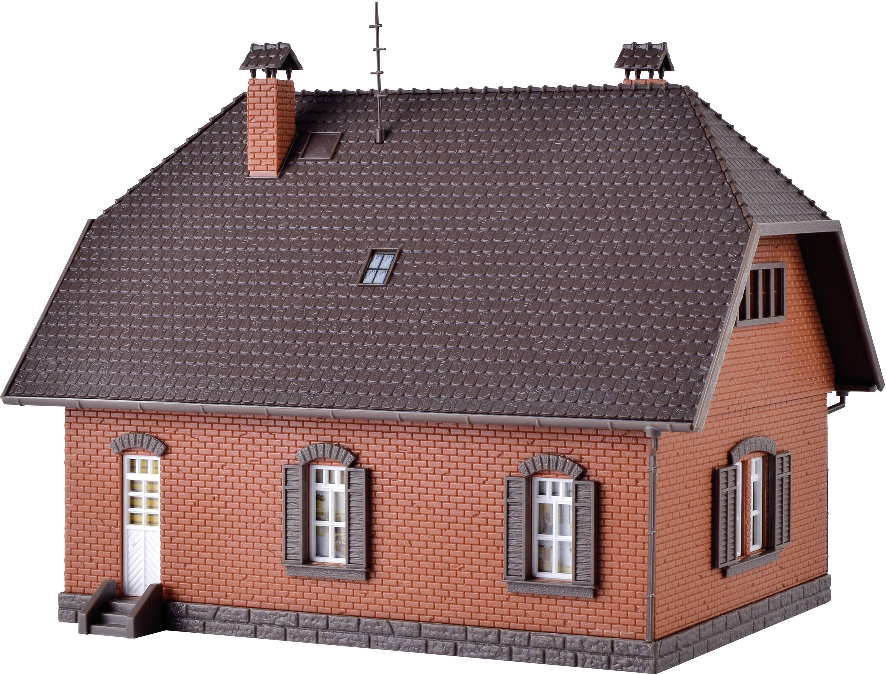 Backstein-Gebäude mit Satteldach, Schornsteinen und weißen Fenstern. Das Haus hat zwei Etagen und ist aus rotbraunen Ziegeln gebaut.