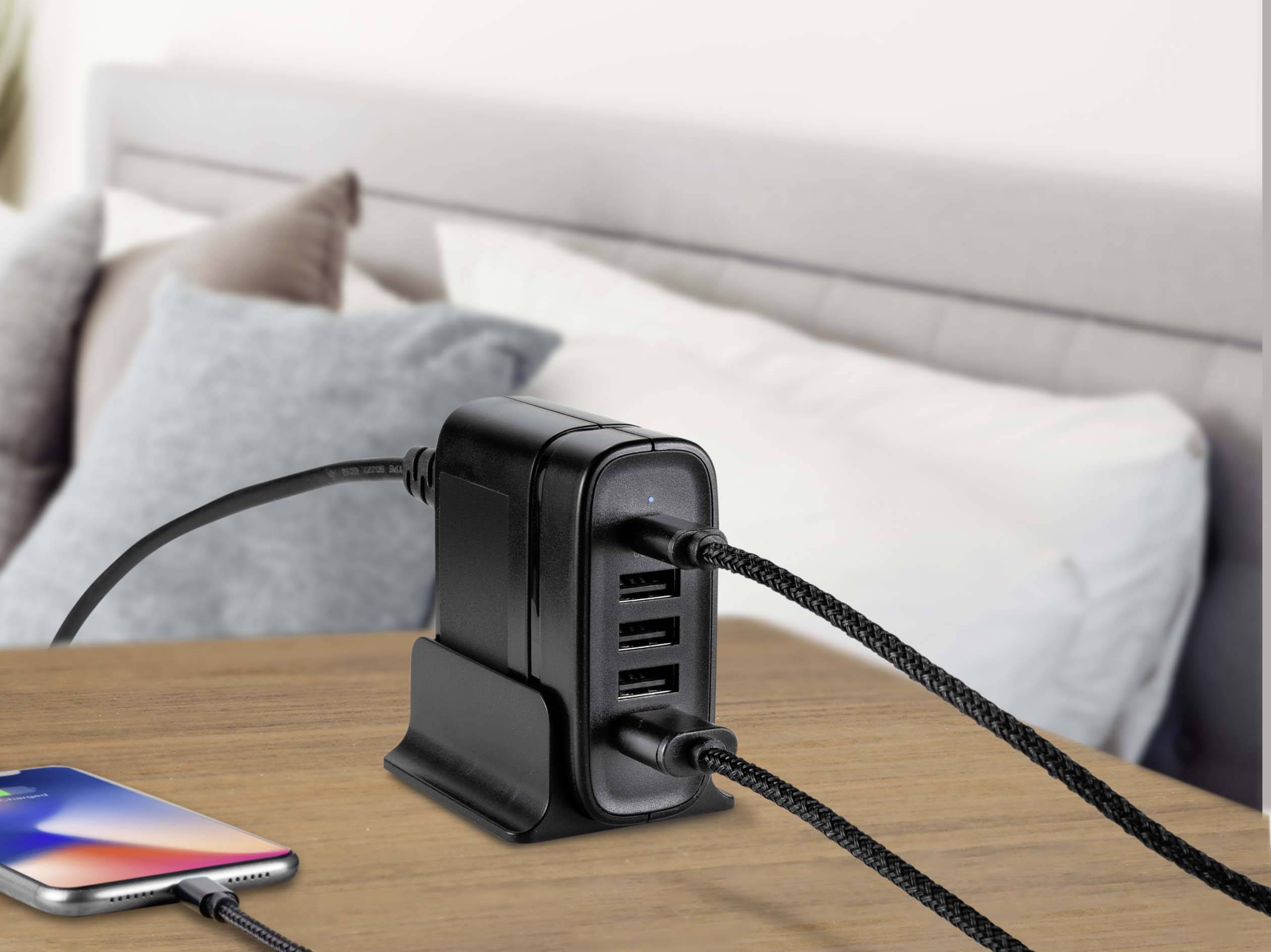 Mehrfach-USB-Ladegerät auf einem Tisch, lädt ein Smartphone. Gerät verfügt über mehrere Anschlüsse, betont seine Funktionalität im Haushalt.