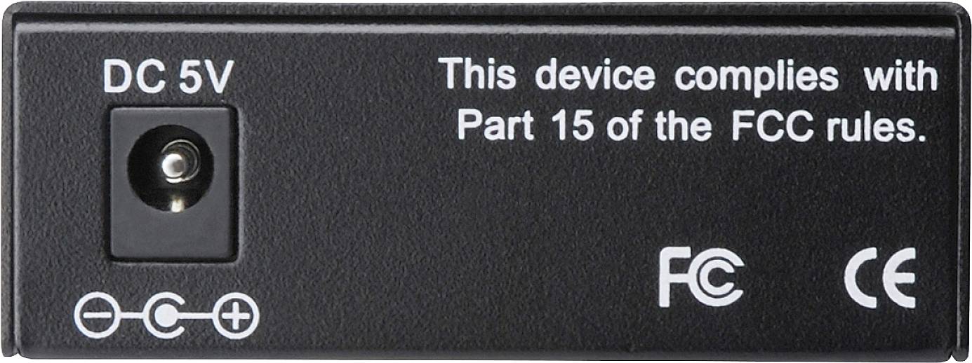 Schwarzes Netzteil, linke Seite: 'DC 5V'-Anschluss. Rechte Seite: Text 'This device complies with Part 15 of the FCC rules', FCC- und CE-Symbole.