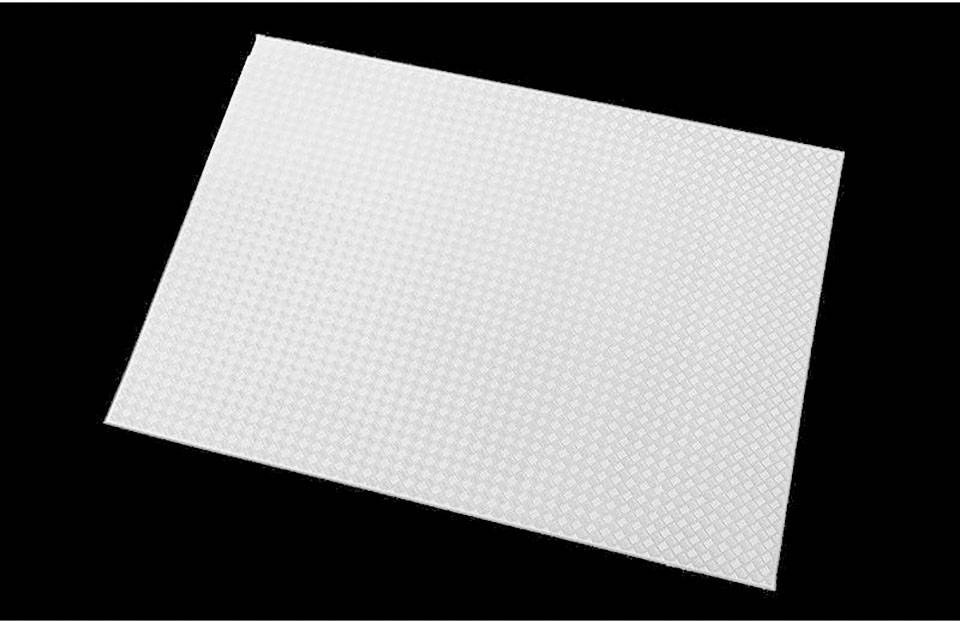 Ein weißes, schräg gelegtes Blatt Papier auf schwarzem Hintergrund. Das Papier hat eine leicht strukturierte Oberfläche.