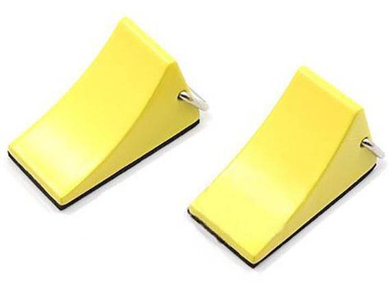 Zwei gelbe, keilförmige Türstopper mit Metallgriffen, nebeneinander liegend. Sie verhindern das Schließen von Türen.