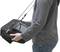 Eine Person trägt ein tragbares Gerät mit einem Bildschirm, befestigt an einem Schultergurt. Das Gerät scheint technischer Natur zu sein.