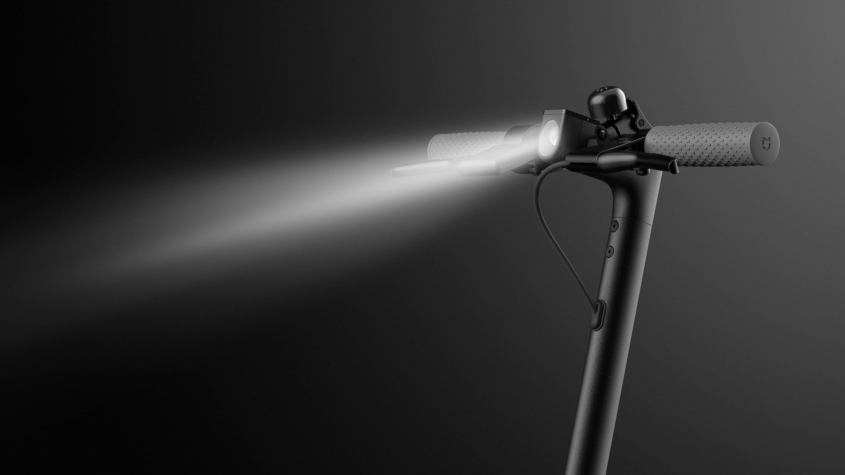Ein Elektroroller-Lenker mit eingeschaltetem Vorderlicht strahlt nach vorne. Der Hintergrund ist dunkelgrau, betont die Beleuchtung.