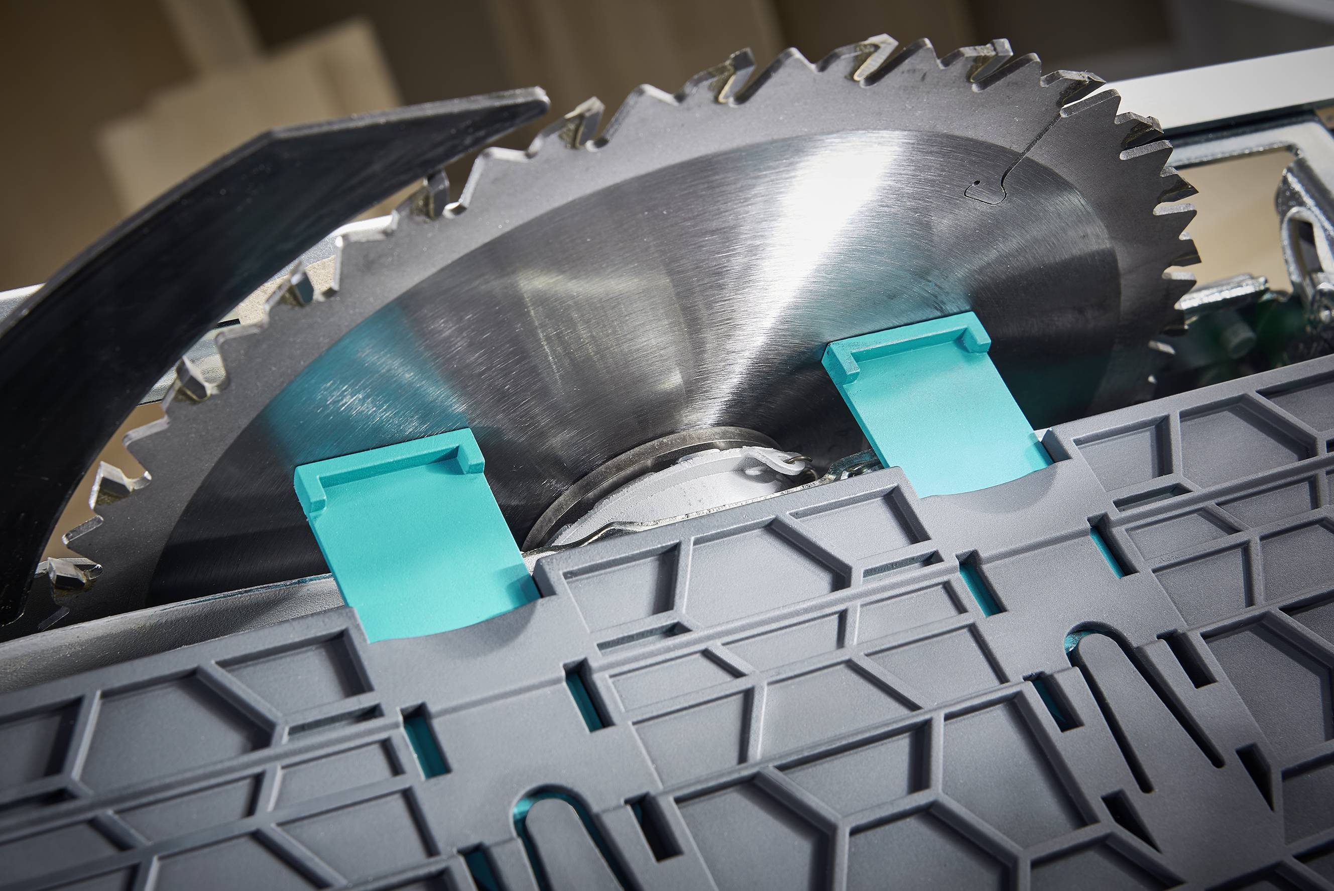 Kreissägeblatt mit zwei blauen Plastikabdeckungen an einem Arbeitstisch, bereit zum Schneiden von Materialien.