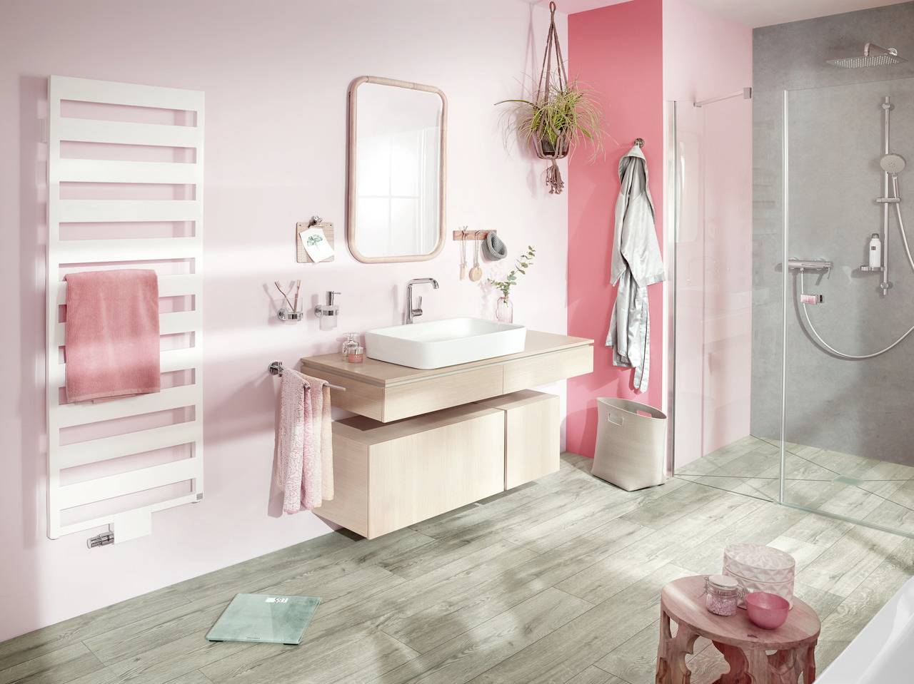 Modernes Badezimmer mit rosa und weißen Wänden, Waschbecken auf Holzunterschrank, an der Wand hängende Handtücher und offene Duschkabine.