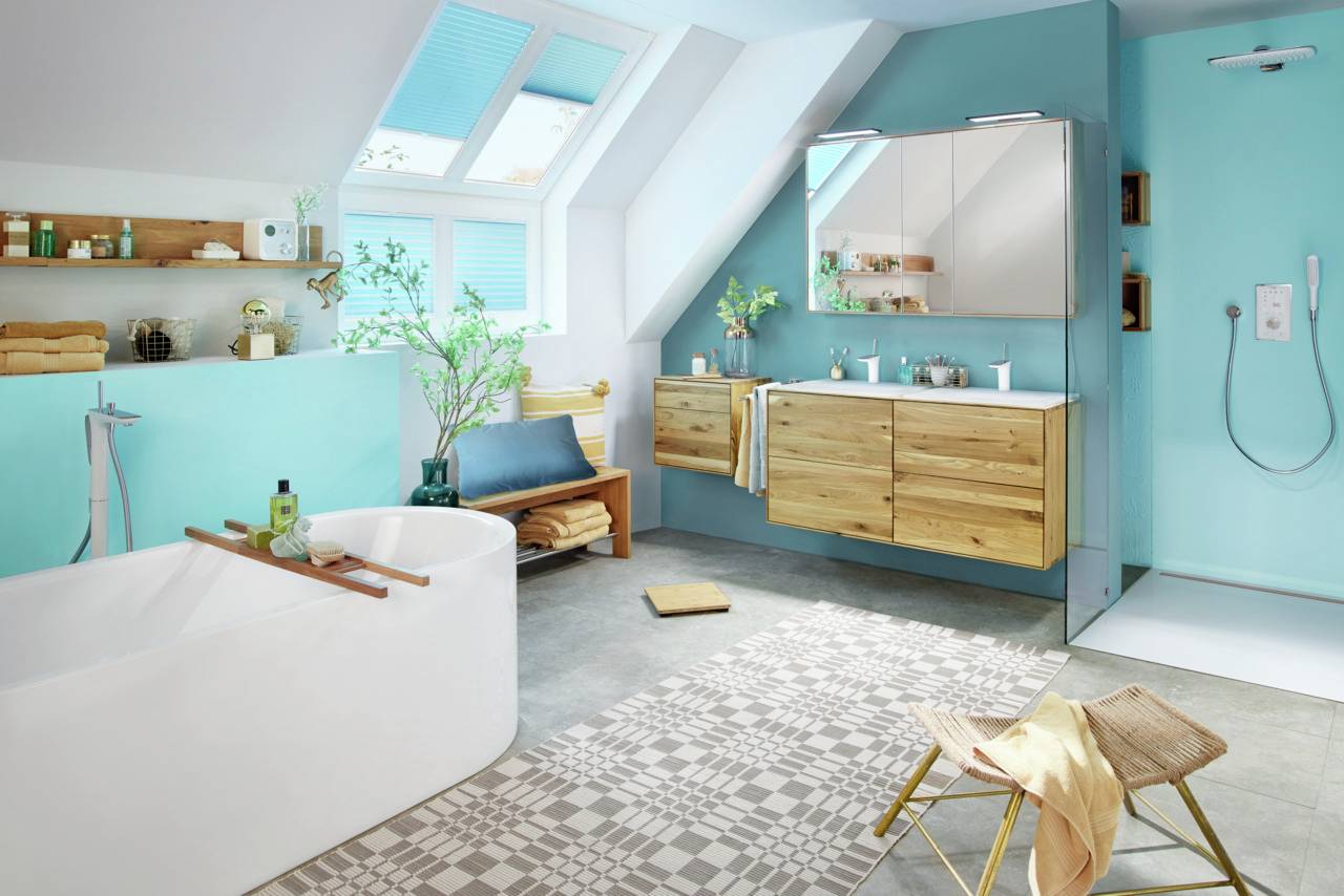 Ein modernes Badezimmer mit freistehender Badewanne, Dusche, Holzregalen und spiegelnden Schränken. Helle Farben und Pflanzen sorgen für Frische.