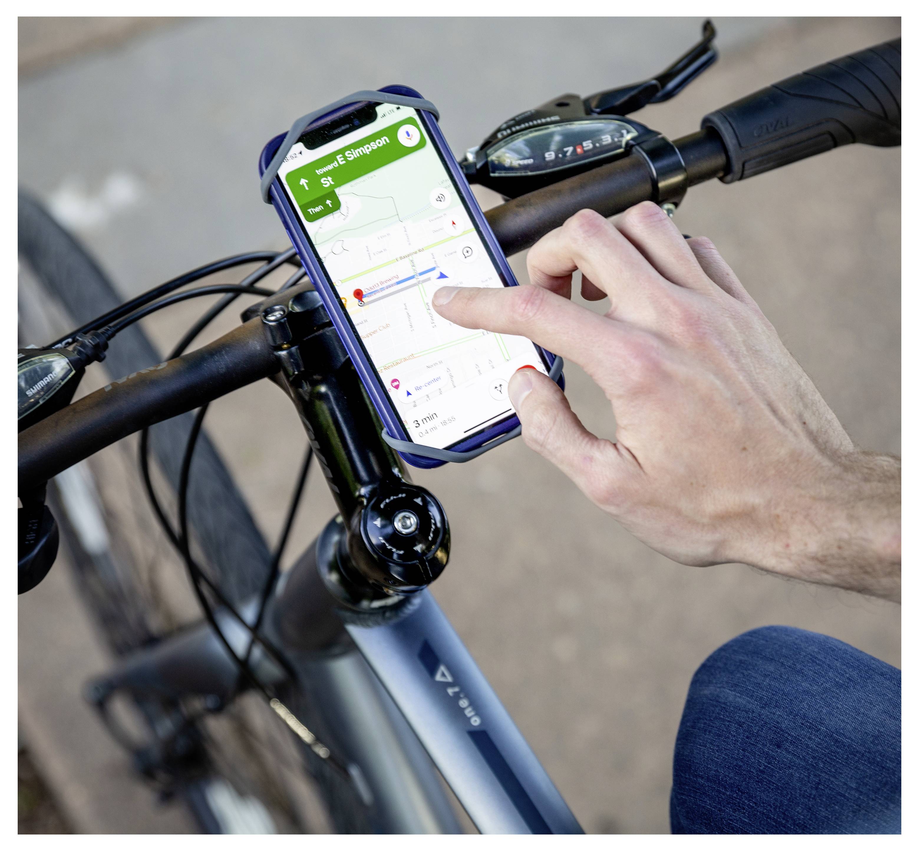 Eine Person benutzt ein Smartphone, das am Fahrradlenker befestigt ist, um sich mit einer Navigations-App zu orientieren und eine Fahrradroute auf dem Bildschirm anzuzeigen.