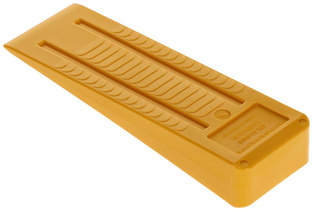 Ein orangefarbener Keil, der als Unterlegkeil für Fahrzeuge verwendet wird. Er hat Rillen für besseren Halt auf unebenem Boden.