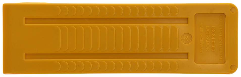 Ein gelbes Kunststoffobjekt mit mehreren parallelen Linien und Mustern. Oben rechts befindet sich ein rechteckiges, leeres Feld.