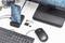 'Computerarbeitsplatz mit Tastatur, Maus, Monitor und Smartphone im Docking-Stationsmodus. USB-Stick und microSD-Karten auf dem Tisch.'