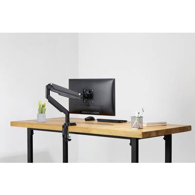 Ein moderner Schreibtisch mit Holzplatte und schwarzem Metallgestell. Darauf stehen ein Monitor mit Gelenkarm, ein kleiner Kaktus und Stifte.
