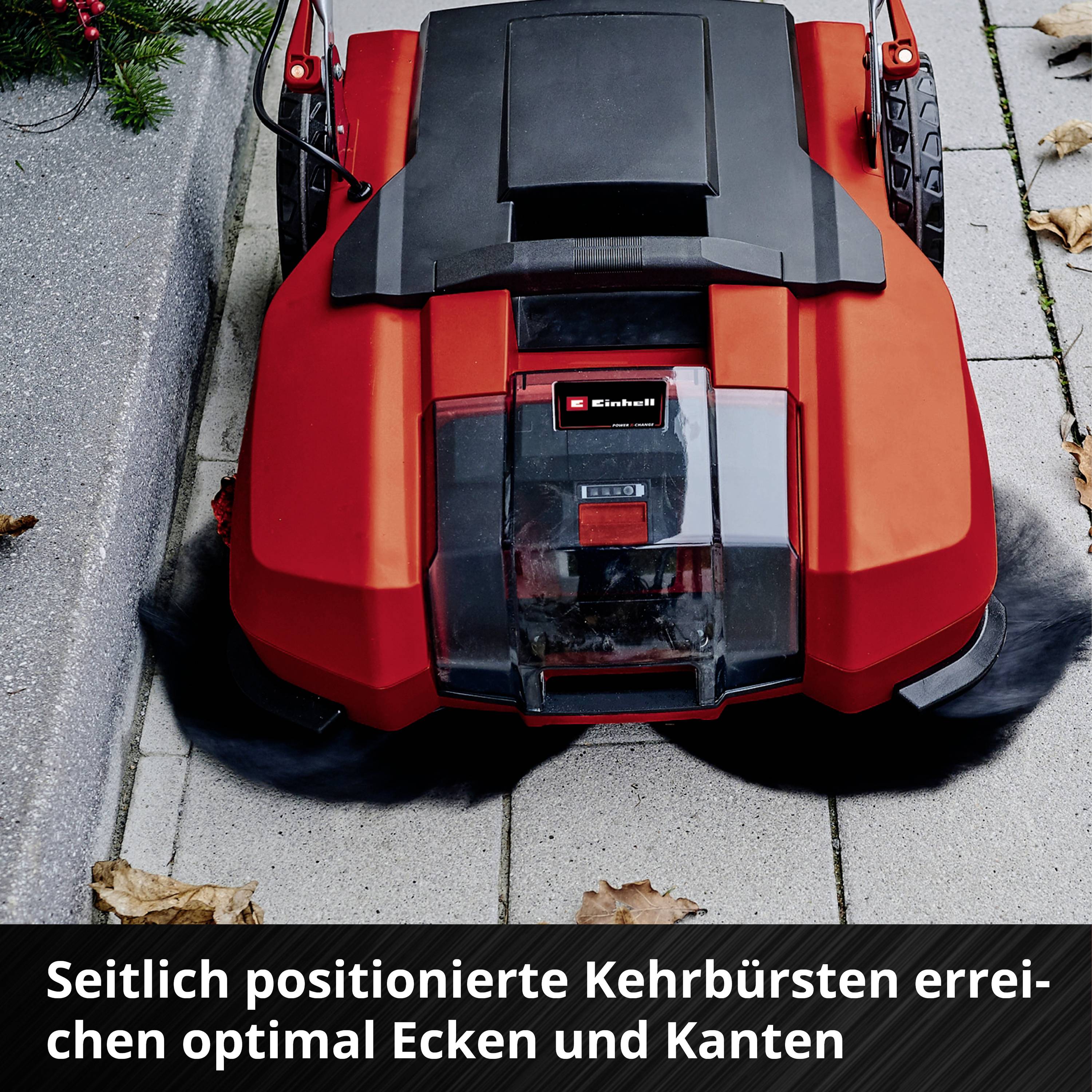 'Ein roter Rasenroboter auf einem Gehweg mit hervorgehobener Funktion: seitlich positionierte Kehrbürsten für die Reinigung von Ecken.'