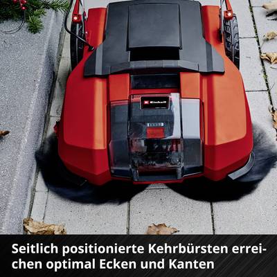 'Ein roter Rasenroboter auf einem Gehweg mit hervorgehobener Funktion: seitlich positionierte Kehrbürsten für die Reinigung von Ecken.'