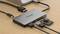 USB-C-Hub mit mehreren Anschlüssen, darunter USB-A, Ethernet, HDMI und SD-Kartenleser. Verbunden mit einem Laptop.