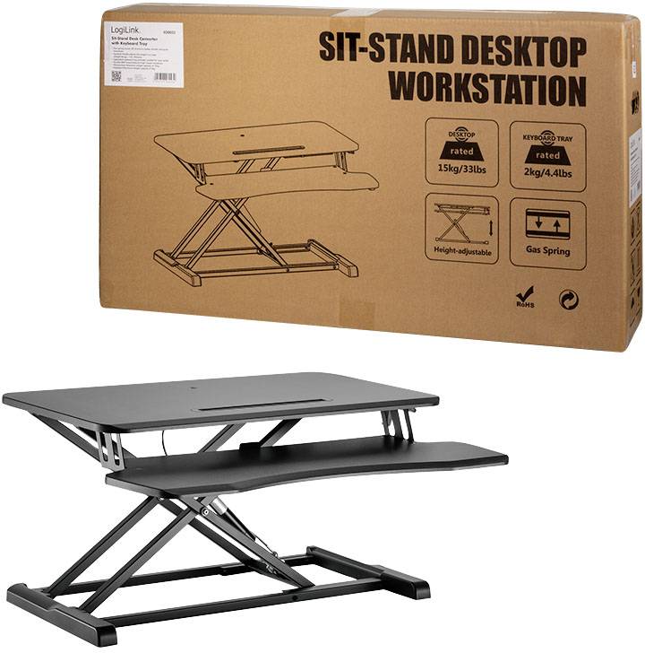 Ein höhenverstellbarer Schreibtischaufsatz in schwarz, verpackt in einem braunen Karton mit der Aufschrift 'SIT-STAND DESKTOP WORKSTATION'.