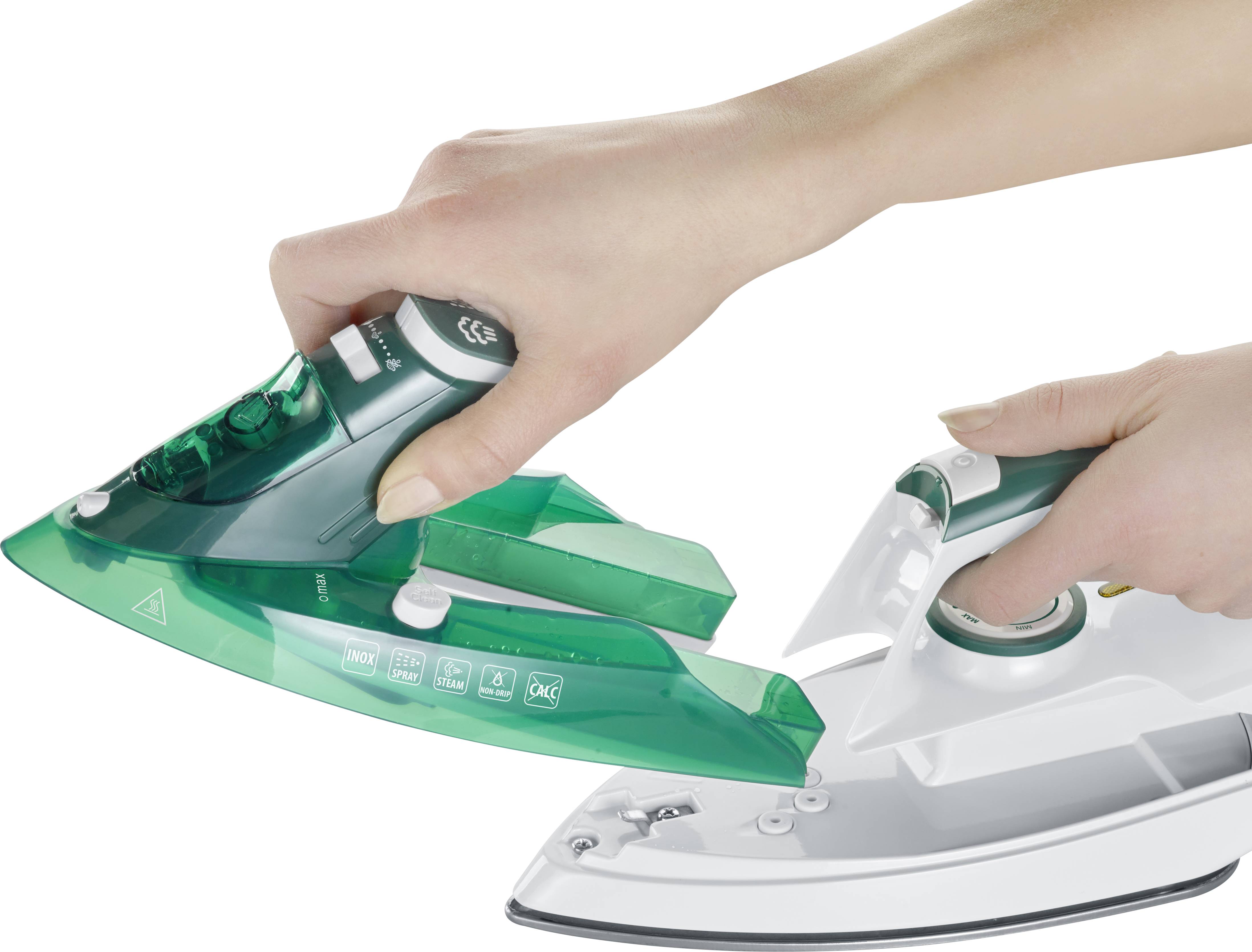 Eine Hand entfernt ein grünes Bügeleisen vom weißen Ladeständer.