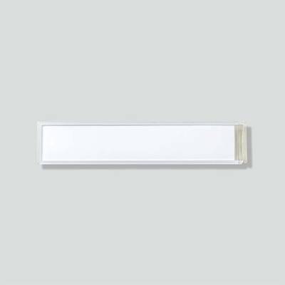 Eine rechteckige, moderne Wandleuchte mit klaren Linien und neutraler Farbgebung. Sie ist horizontal an einer grauen Wand montiert.