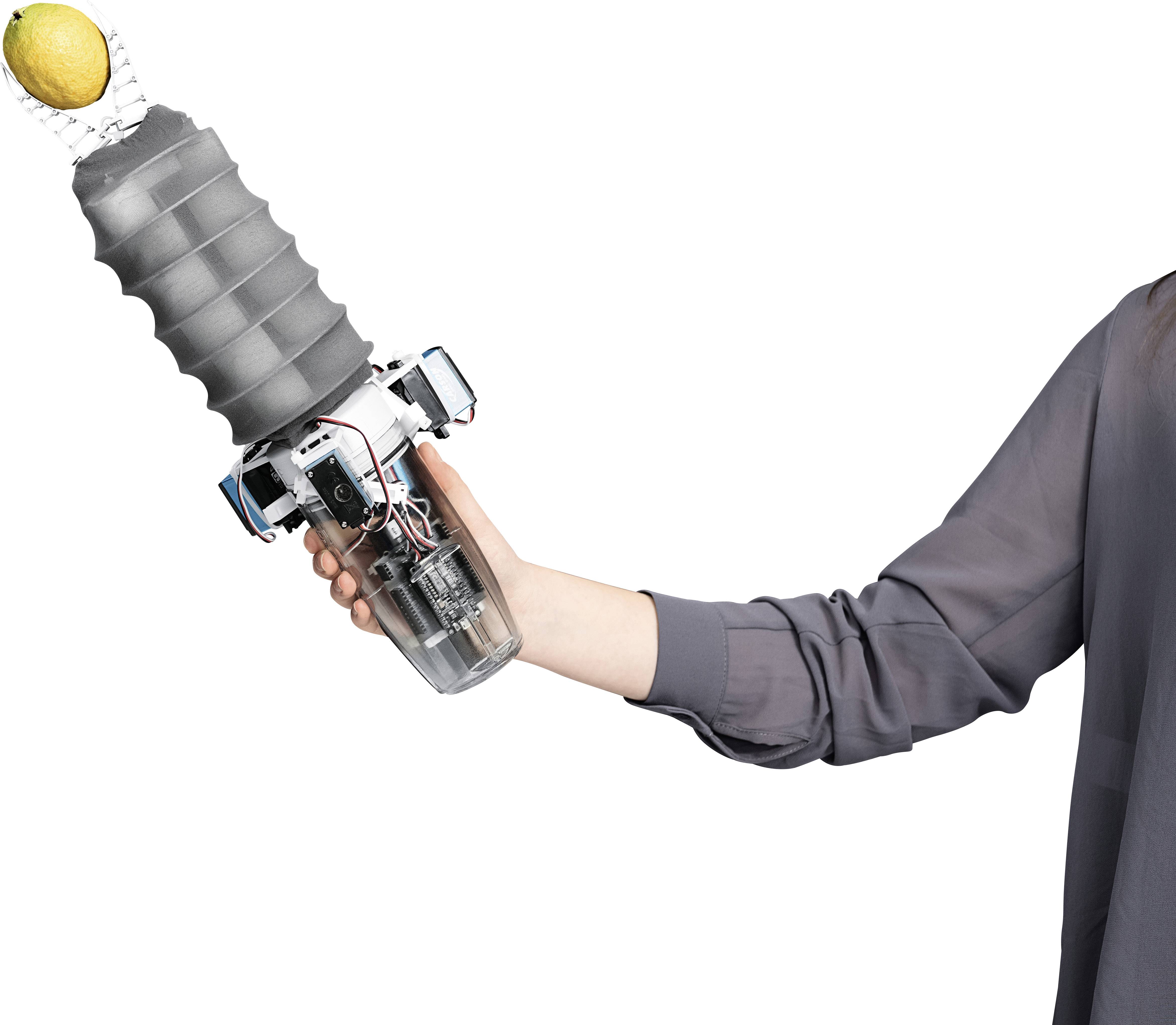 Eine Person hält einen Roboterarm mit einem flexiblen Greifer, der eine Zitrone hebt. Der Arm zeigt moderne Technologie.