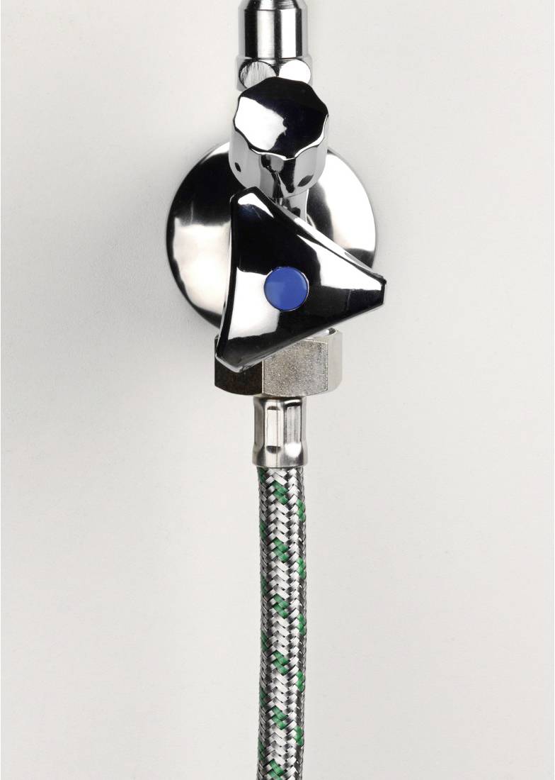 Ein verchromtes Ventil mit einem blauen Punkt an der Vorderseite, verbunden mit einem geflochtenen Schlauch, an einer Wand montiert.