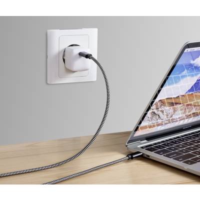 Ein Laptop wird mit einem Stromkabel an eine Steckdose angeschlossen. Das Kabel hat ein geflochtenes Muster.