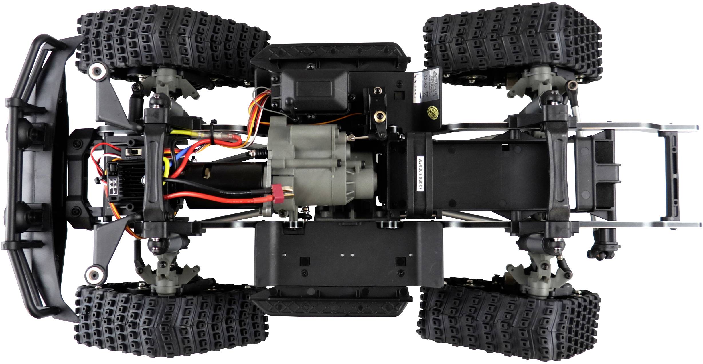 Ein ferngesteuertes Fahrzeug von unten gezeigt. Sichtbar sind Motor, Batteriefach, Kabel und robuste Geländereifen.