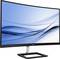 Ein gebogener Philips-Monitor mit einem schlanken Design, zeigt einen abstrakten blauen Hintergrund auf dem Bildschirm.