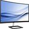 Ein gebogener Monitor von Philips mit einem modernen Design, schwarzem Rahmen und stabilem Standfuß. Display zeigt blaue Wellenlinien.