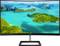 Ein gebogener Computermonitor zeigt ein tropisches Inselpanorama mit smaragdgrünem Wasser und bewaldeten Inseln unter blauem Himmel.