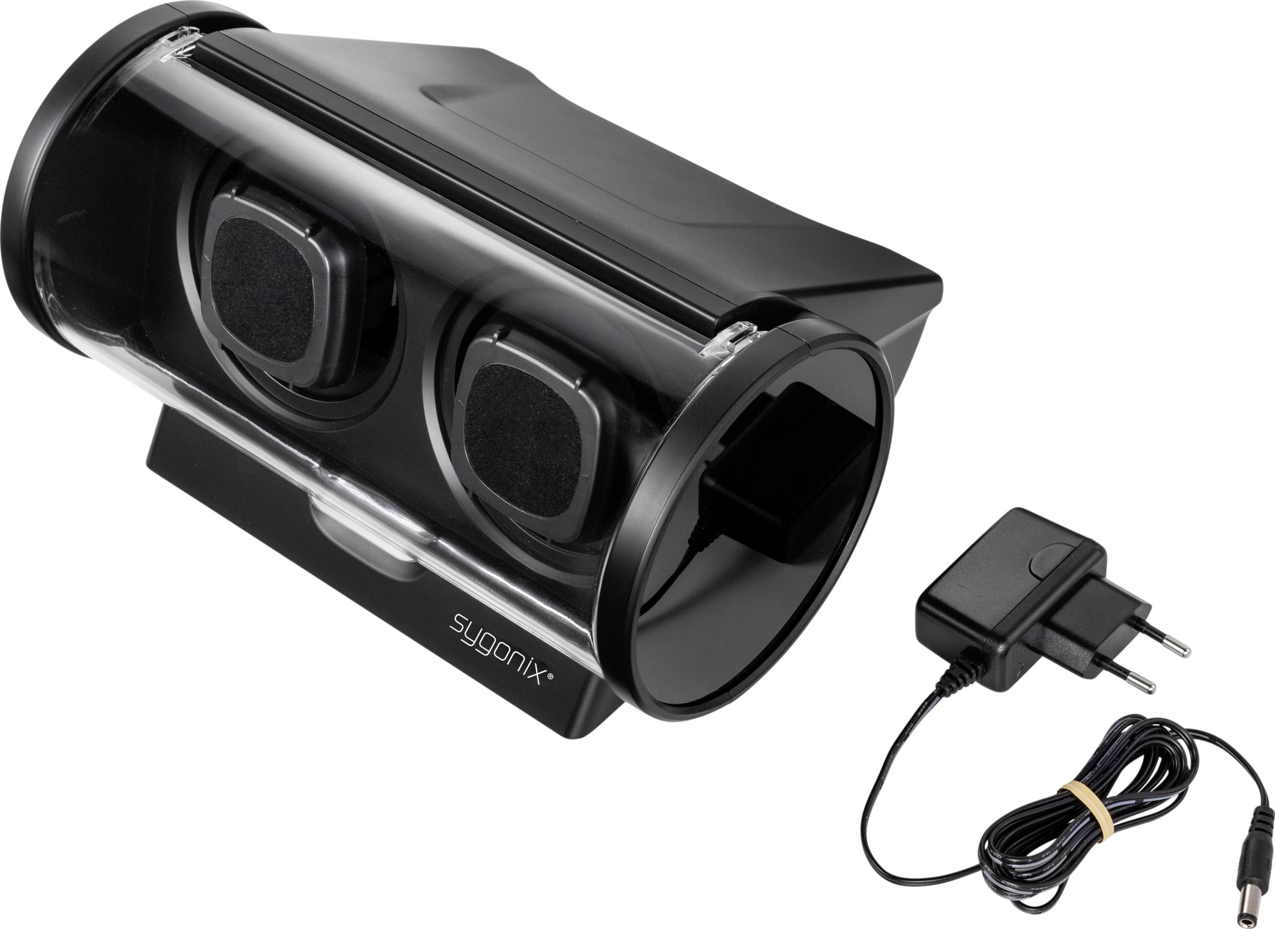 Ein schwarzes elektrisches Gerät mit zwei Lüftungsschlitzen, daneben ein Steckernetzteil mit Kabel.