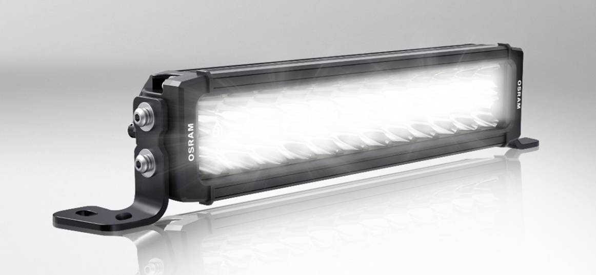 LED-Lichtleiste mit schwarz-silbernem Gehäuse, montiert auf einer Halterung zur Verwendung in Fahrzeugen oder industriellen Anwendungen.