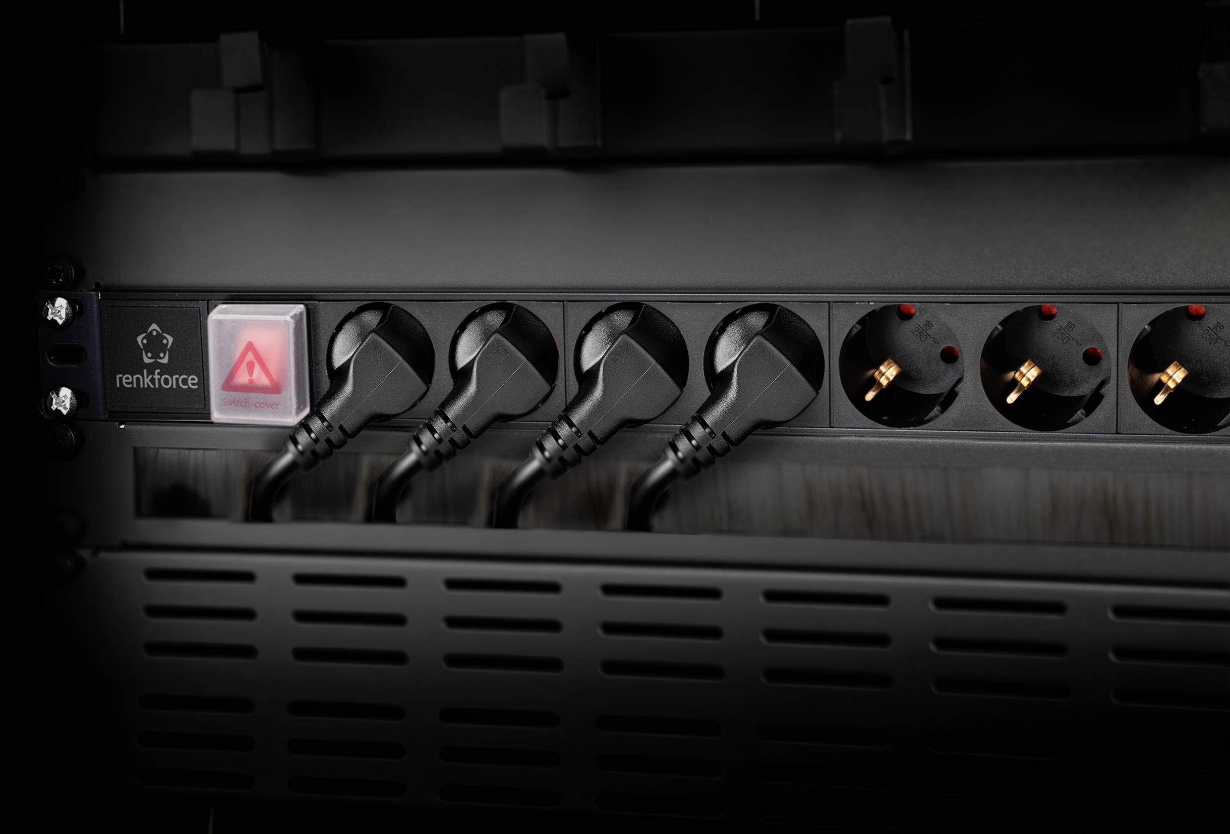 Eine schwarze Steckdosenleiste mit fünf eingesteckten Kabeln. Links befindet sich ein roter Schalter und das Herstellerlogo.