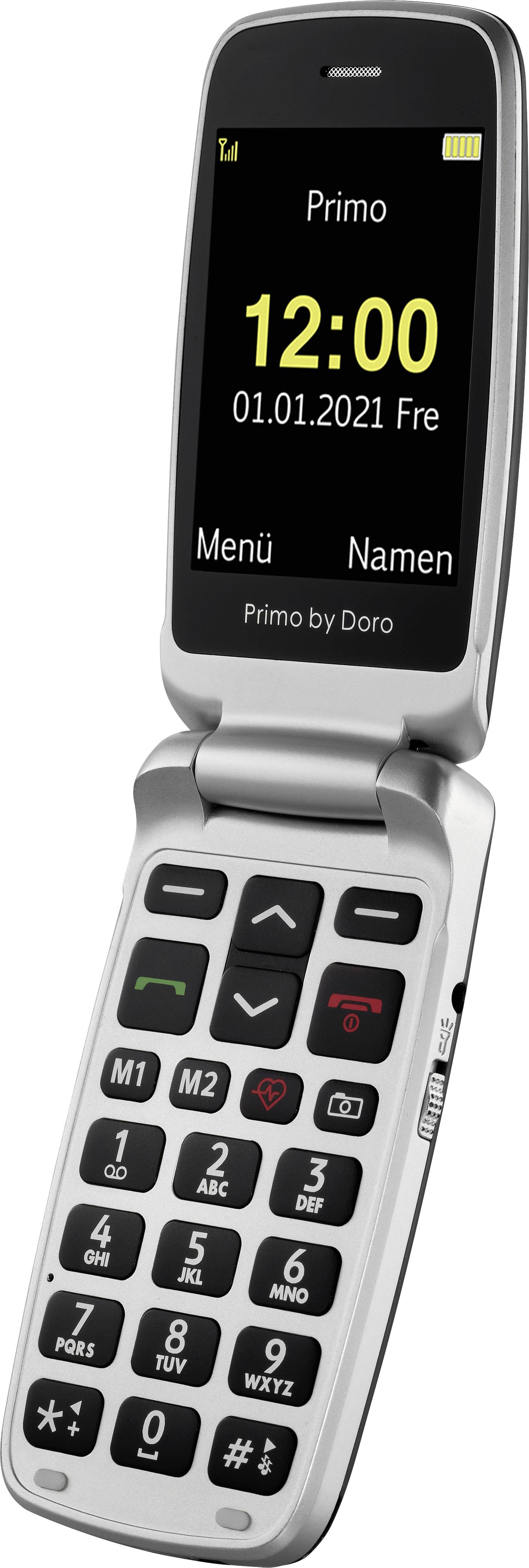 Ein silbernes Klapphandy mit großen Tasten und einem Display, das '12:00, 01.01.2021 Fre' anzeigt. Oben steht 'Primo'.