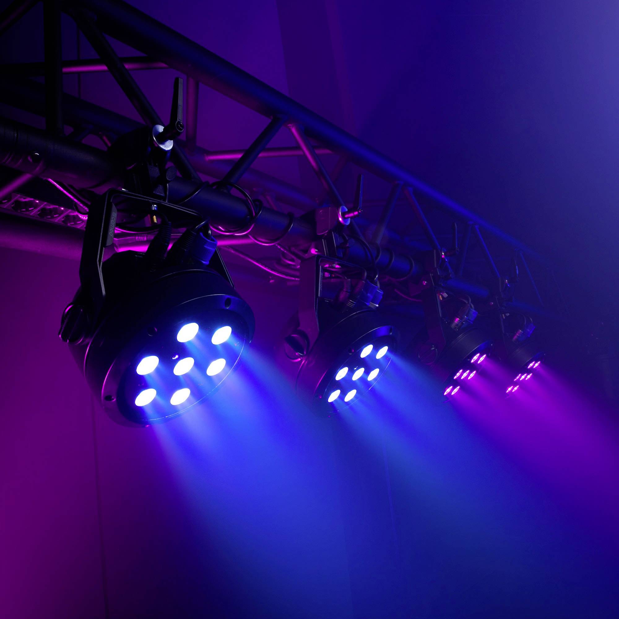 Bühnenbeleuchtung in Magenta und Blau beleuchtet eine leere Bühne. Lichter sind an einem Gestänge befestigt, mit intensiven Strahlen.