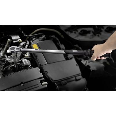 Ein Drehmomentschlüssel wird von einer Hand genutzt, um eine Schraube im Autoteilbereich anzuziehen. Mechanische Wartungsszene.