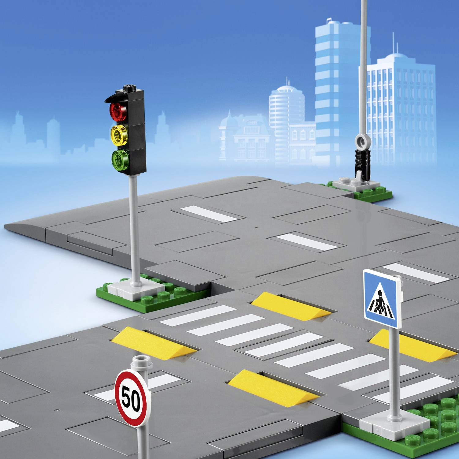 Eine modellhafte Straßenkreuzung aus Spielzeugsteinen mit Ampel, Zebrastreifen, Verkehrszeichen und Gebäuden im Hintergrund.