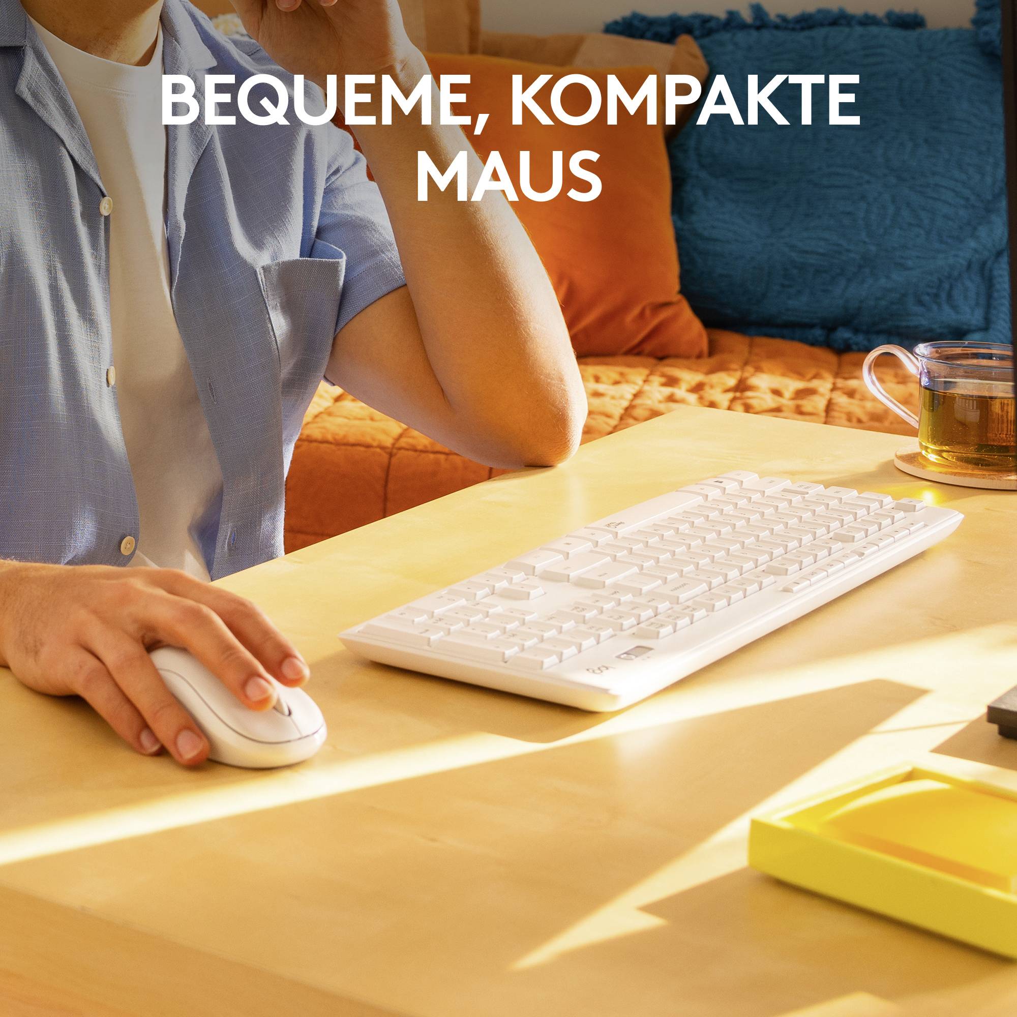 'Person sitzt an einem Schreibtisch mit Tastatur, hält eine Maus; Text oben: Bequeme, kompakte Maus.'