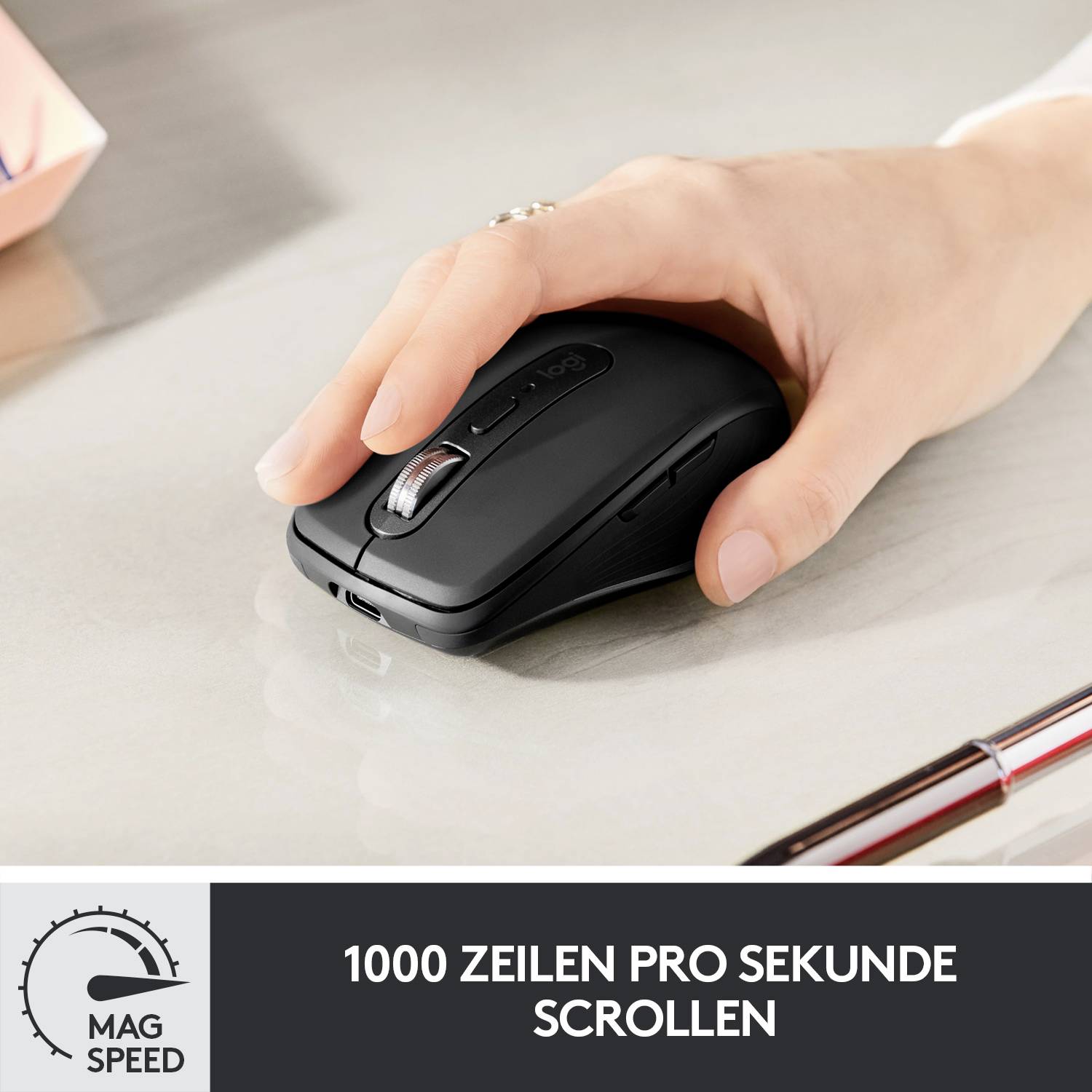 Eine Hand hält eine schwarze Computermaus auf einem Tisch. Text: '1000 Zeilen pro Sekunde scrollen', zeigt schnelle Scrollfunktion.