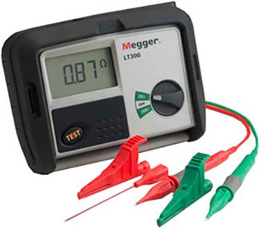 Ein digitales Messgerät zeigt einen Widerstand von 0,87 Ohm. Es ist mit roten und grünen Kabelklemmen ausgestattet.