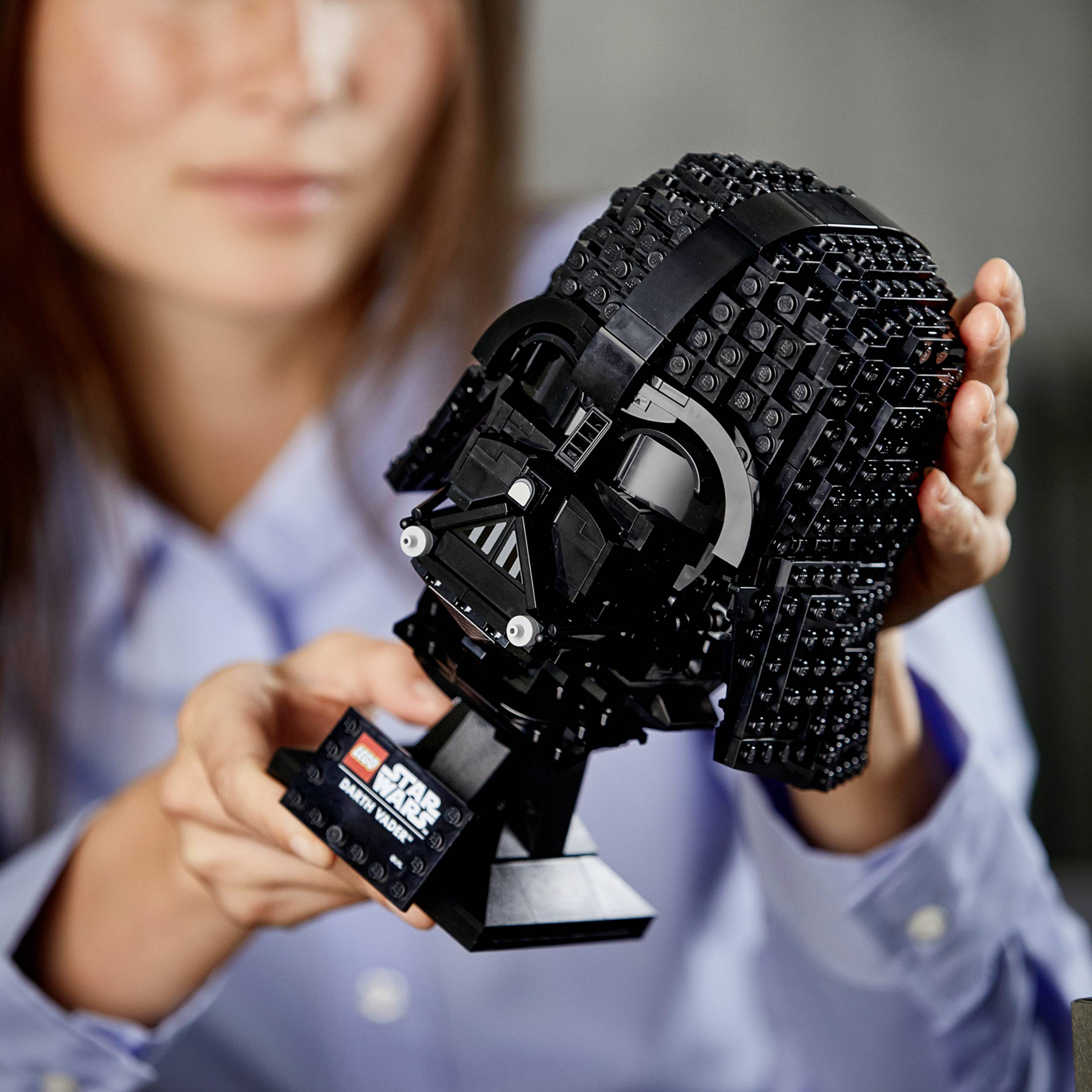 Eine Person hält eine detailreiche Lego-Büste einer bekannten Science-Fiction-Figur mit Helm.