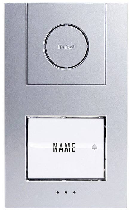 Klingel mit Namensschild und Kamera; silbernes Design, runder Klingelknopf oben, rechteckiges Namensschild unten, drei kleine Punkte unten.