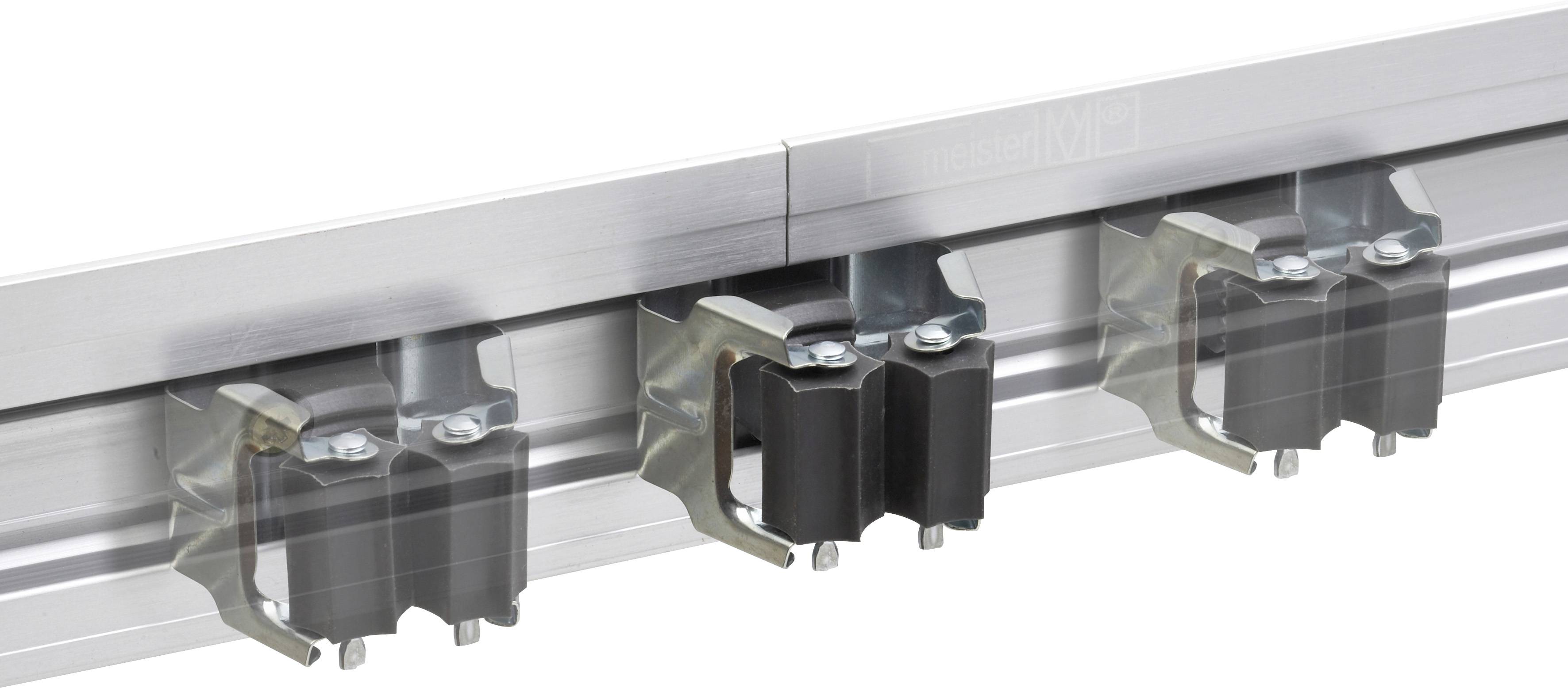 Metallschiene mit mehreren angebrachten Klemmen. Sie sind symmetrisch angeordnet und halten Objekte auf einem Aluminiumprofil.