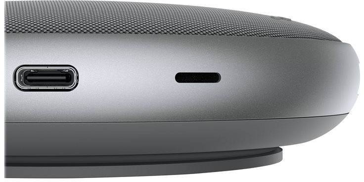 Flacher, runder grauer Lautsprecher mit USB-C-Anschluss und weiterer Öffnung an der Seitenfläche; Ansicht von der Seite.